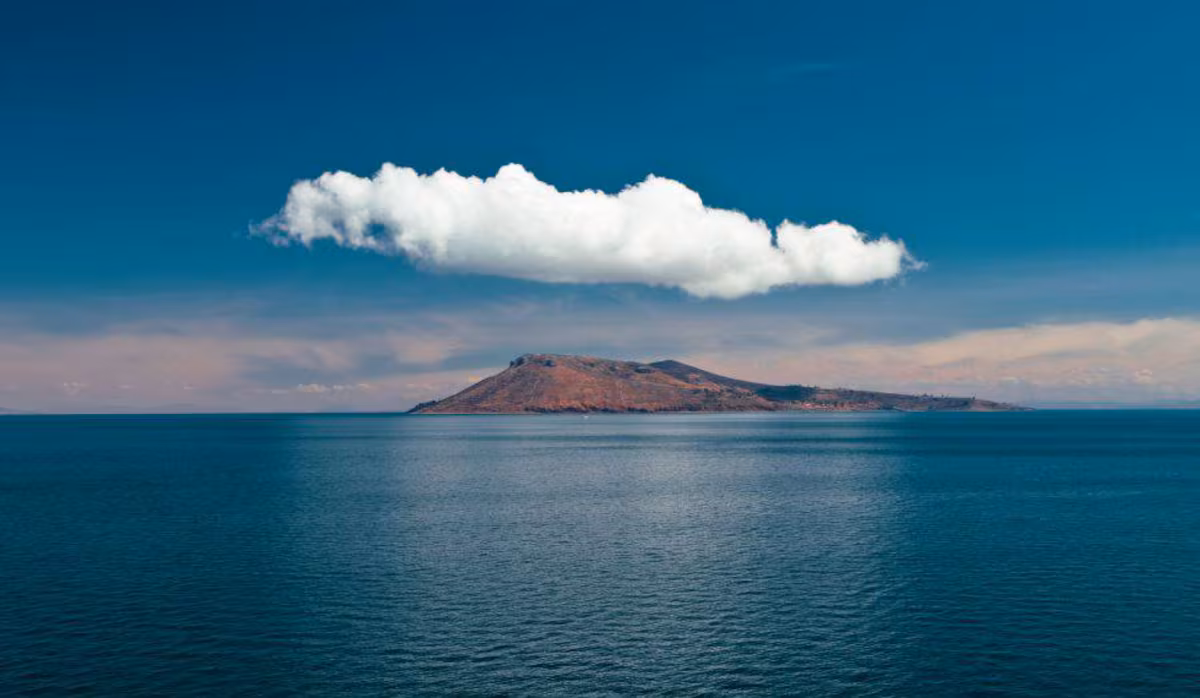 Paisaje de un lago y montañas bajo el cielo de Bolivia